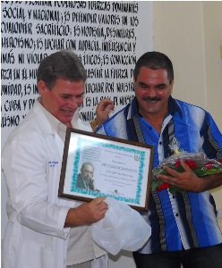 El doctor Ernesto Pillado Fernández, director CPHEM, de Camagüey, (a la izquierda), entregaba el reconocimiento al doctor Eydel Miguel. médico _ébola_cuba