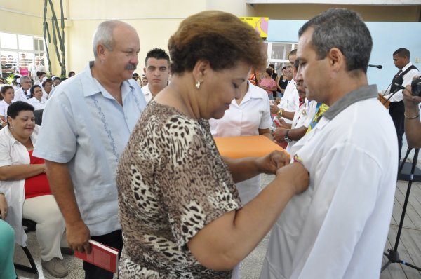 Olga Lidia Tapia Iglesias, miembro del Secretariado del Comité Central del Partido Comunista de Cuba, colocaba la Orden Carlos J. Finlay al Dr. Leosvel Pérez Gutiérrez, uno de los profesionales de la Salud que enfrentó el virus del Ébola en África Occidental, quien ofreció servicios también en Guatemala y la República Bolivariana de Venezuela.
