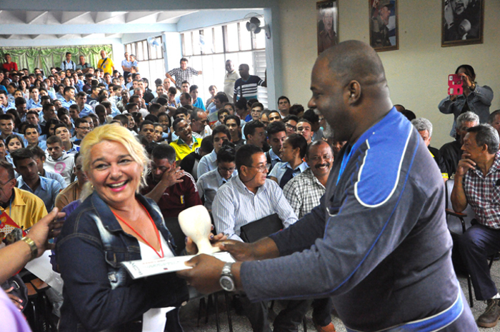 La jefa de la delegación de Camagüey recibe la copa que le acredita el segundo lugar nacional. Foto: Tomada del periódico La Demajagua