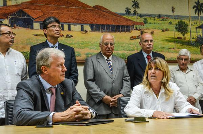 Irma Martínez Castrillón, ministra presidenta del Banco Central de Cuba, y Nick Rischbieth, presidente ejecutivo del Banco Centroamericano de Integración Económica, durante la firma de acuerdos entre ambas instituciones, al centro de pie, Ricardo Cabrisas Ruiz, vicepresidente del Consejo de Ministros y ministro de Economía y Planificación, en la sede del BCC, en La Habana. FOTO: Marcelino Vázquez Hernández/ ACN