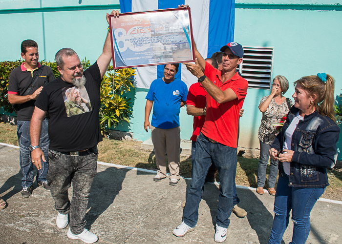 El director (a la izquierda) y el secretario general del ejecutivo sindical reciben el galardón.Foto: Leandro Pérez Pérez/ Adelante Combinado lácteo Nuevitas, inspirador de hazañas