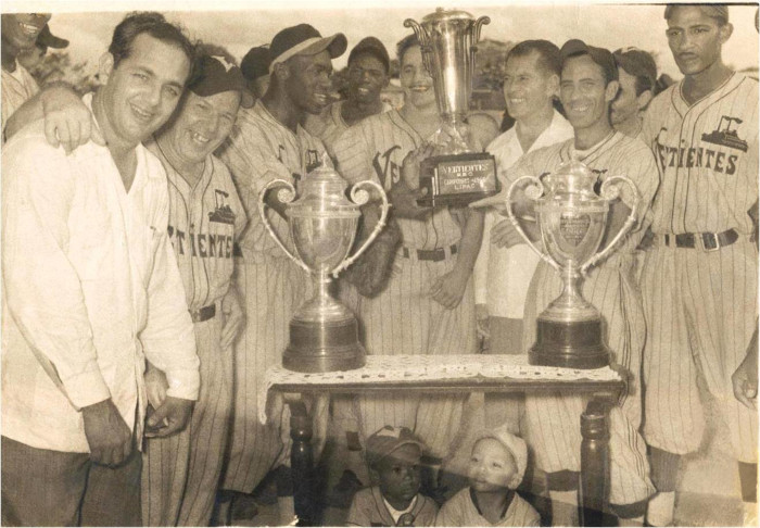 Mario Pérez (primero de derecha a izquierda) festeja un título con el Vertientes, mientras su hijo Omar posa debajo de los trofeos. Fotos: Archivo del autor Pelota de padres a hijos