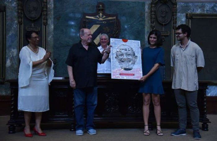 Silvio recibió una carpeta con carteles creados por estudiantes de Diseño, que aluden a sus canciones emblemáticas. Foto: ACN Silvio Rodríguez dedica título universitario a la trova cubana